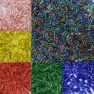 Macro shot of colorful glass bugle beads in metallic and iridescent finishes for DIY jewelry