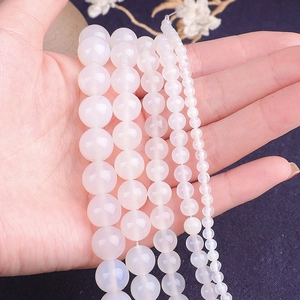 Détail macro de perles d'agate blanche en cinq tailles pour la création de bijoux