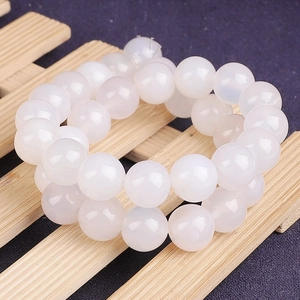 Détail macro de perles d'agate blanche lisse au lustre gras pour la bijouterie