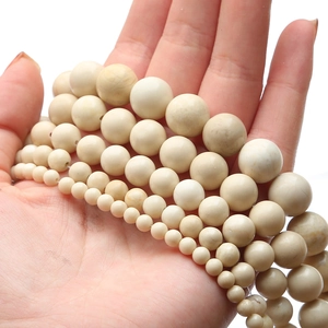 Vue macro de perles rondes en fossile blanc naturel de tailles variées pour bijoux DIY