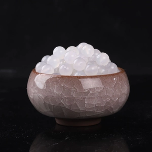 Perles rondes en agate blanche polie pour création bijoux dans un bol céramique