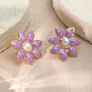 Elegantes pendientes de flores en esmalte morado con perlas y bordes dorados en piedra
