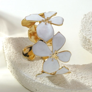 Golden stainless steel open bangle featuring two elegant white enamel flowers on stone