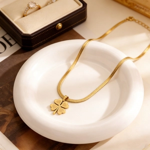 Dettaglio della collana a quadrifoglio dorata con catena a serpente e set gioielli coordinati