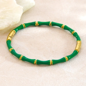 Détail du bracelet style bambou en acier inoxydable avec émail vert et finition or