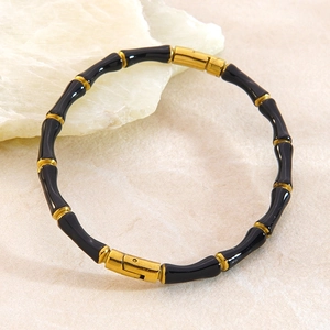 Détail macro du bracelet bambou en acier inoxydable noir et or avec fermoir à pression