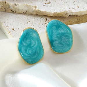 Boucles d'oreilles dorées irrégulières avec résine marbrée bleue et forme organique