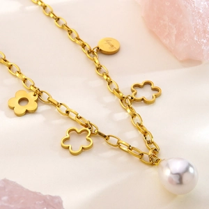 Close-up of 18k gold flower necklace with Lucky tag and drop pearl on pink crystal