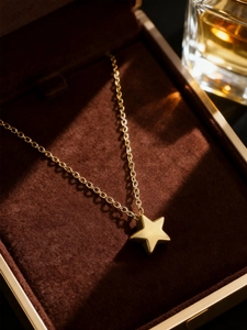 Macro view of a polished golden star pendant necklace resting on a brown velvet jewelry box