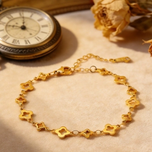 Elegantes 18k vergoldetes Edelstahl-Vierblatt-Kleeblatt-Armband auf Vintage-Hintergrund