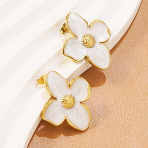 Detailed close-up of gold-plated white floral stud earrings with marble texture details