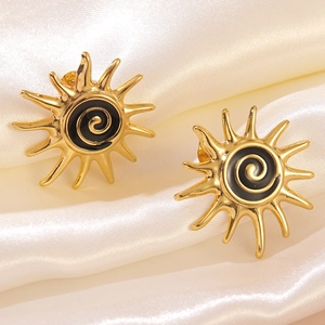 Detail of golden stainless steel sun stud earrings with black enamel and spiral design