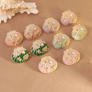 Starfish and seashell earrings with colorful enamel and pearl accents on brown texture