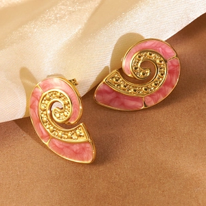 Detail of gold-plated conch stud earrings with pink marble enamel on silk fabric background