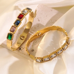 Close-up of gold stainless steel bangles with colorful rectangular zircon stones