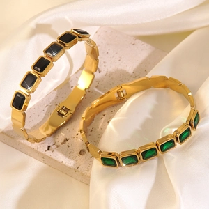 Detail view of gold-plated stainless steel bracelets with black and green zircons