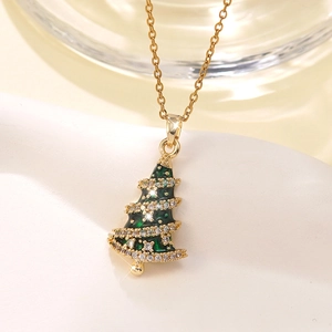 Close-up of golden Christmas tree necklace with green enamel and sparkling crystals