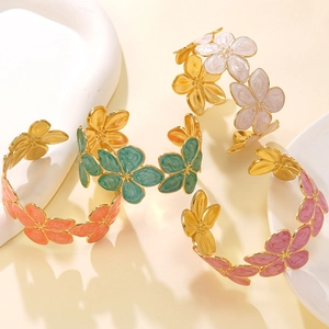 Dettaglio di bracciali a fiori in smalto e acciaio dorato con petali variopinti