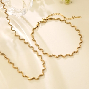 Gouden roestvrijstalen sieradenset met golvende ketting en armband in moderne stijl