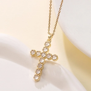 Detailed close-up of a gold cross pendant featuring shimmering zircon stones on an O-chain