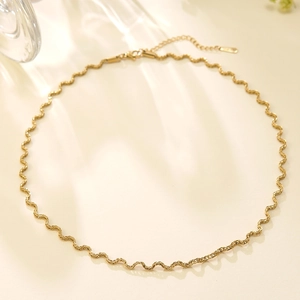 Detail van gouden golvende ketting met kreeftsluiting en verstelbare verlengketting
