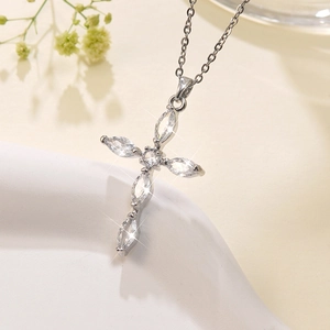 Detailed close-up of a silver cross pendant featuring sparkling marquise-cut crystals
