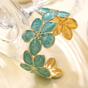 Bracciale rigido aperto in acciaio dorato con design floreale in smalto blu