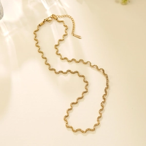 Detail van de gouden golvende ketting met karabijnsluiting en verstelbare verlengketting
