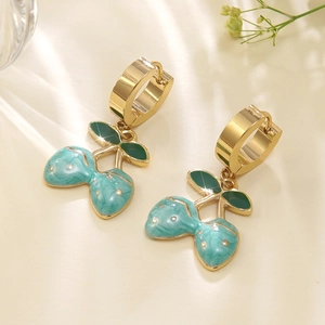 Detail of gold cherry earrings with blue marble texture and green enamel leaves