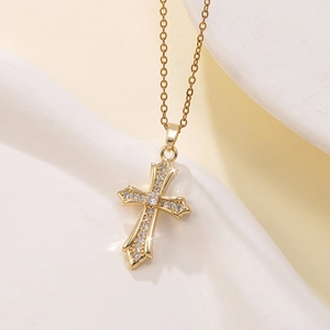 Macro shot of gold cross necklace with micro-pave cubic zirconia on baroque pendant