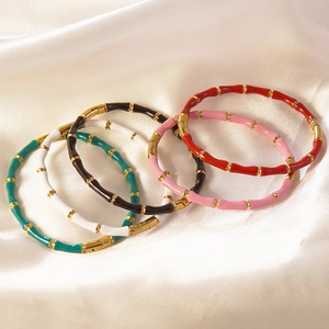 Detailansicht von Emaille-Armbändern im Bambus-Stil in fünf Farben auf Seidenstoff