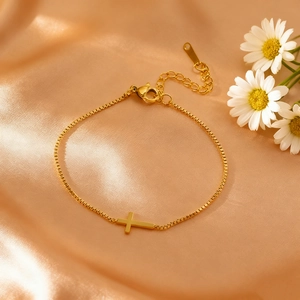 Elegantes goldenes Kreuzarmband mit Zirkonia auf luxuriöser Seide mit Gänseblümchen
