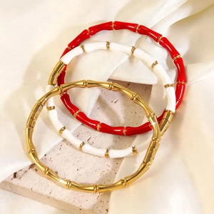 Detailed view of bamboo-shaped bangles in gold, red, and white enamel finish