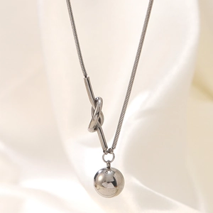 Polished stainless steel knot necklace with round ball pendant on white silk background