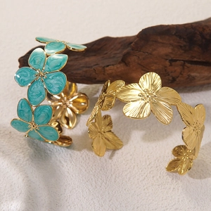 Detailansicht eines Emaille-Blumenarmreifs mit blauen Blüten und Gold-Struktur