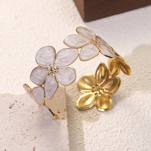 Details des blumenförmigen Armreifs mit weißen Emaille-Blütenblättern und Goldfinish