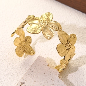 Goldener Edelstahl-Armreif mit floralen Elementen und einer fein gebürsteten Textur