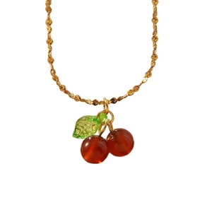 Sweet red cherry pendant necklace with gold twisted chain on a white background