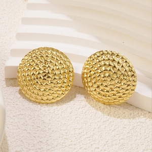 Detailed macro view of gold-plated round stud earrings with textured woven pattern surface