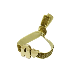 Detalle macro de la pulsera elástica dorada con letra A metálica y pequeño corazón