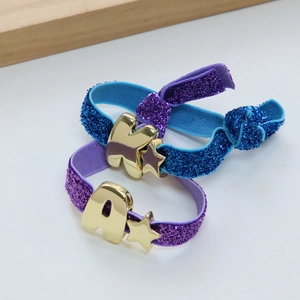 Elastische armbandenset met sterbedeltjes en gouden letters K en A op paarse en blauwe banden