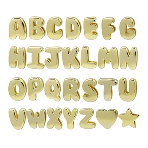 Macro detail of 26 3D golden alphabet letters and star heart charms for DIY jewelry