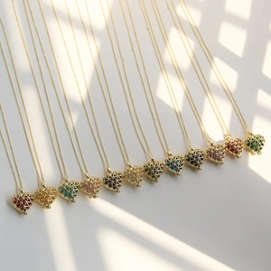 Detail of twelve golden heart-shaped cage pendants with colorful birthstones in a row