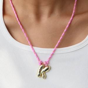 Detail of hand-woven colorful cord necklace with a golden bubble letter K pendant and crystals