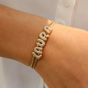 Detail showing a gold-plated double-layer box chain bracelet with LAURA zircon letters