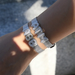 Detailed view of silver mesh bracelets with sparkling MAMA letters on a wrist