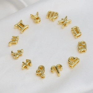 Polished 18k gold plated brass zodiac symbol pendant necklaces set on white silk fabric