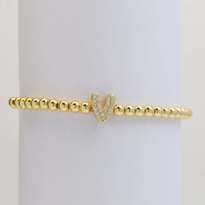 Gold beaded stretch bracelet featuring a micro-pave zircon letter V pendant