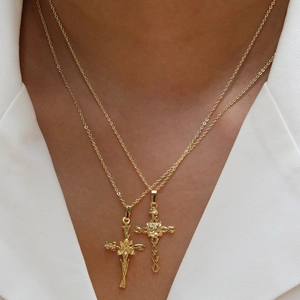 Gold plated brass 18k cross necklaces with flower vine detail on white suit background