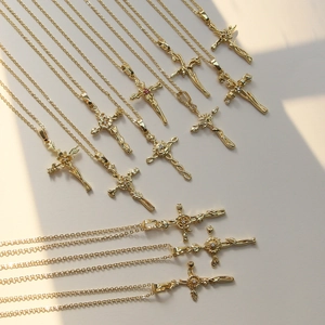 Detail of vintage 18k gold plated cross pendants with floral patterns and gemstones